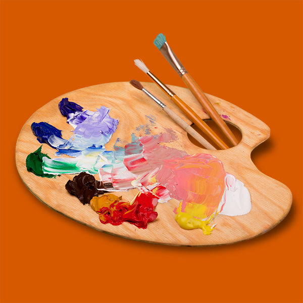 Wooden art palette with blobs of paint and a brushes on an orange background